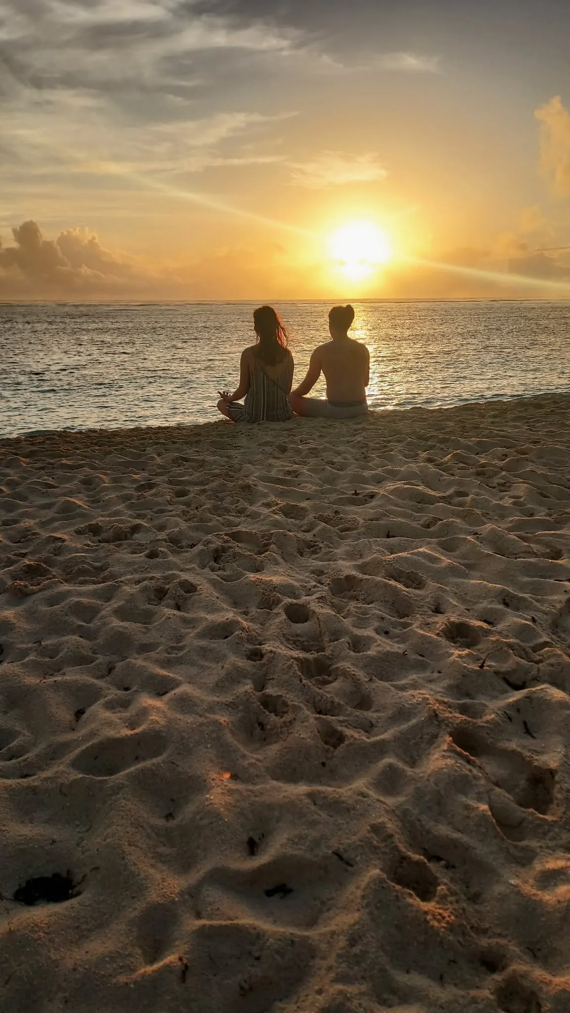 Couple watching sunrise on Alegria Beach